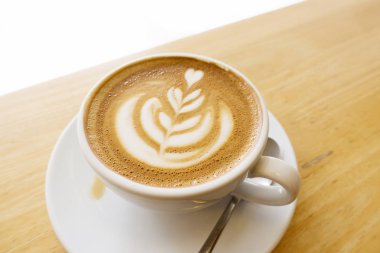 Ahşap bir masa üzerinde sıcak latte