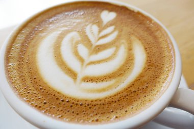 Ahşap bir masa üzerinde sıcak latte                               
