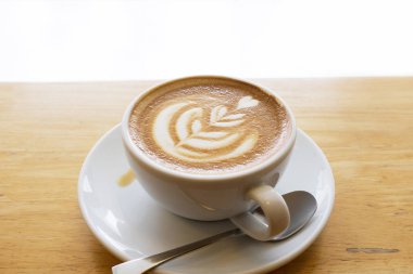 Ahşap bir masa üzerinde sıcak latte