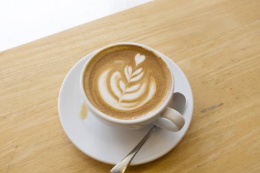 Ahşap bir masa üzerinde sıcak latte