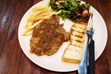 ahşap masa üzerinde domuz eti biftek