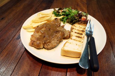 ahşap masa üzerinde domuz eti biftek