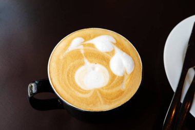 Ahşap masa üzerinde sıcak latte