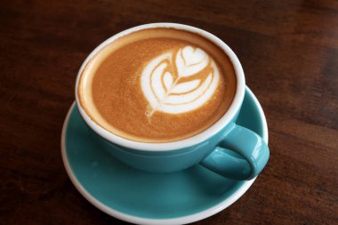 Ahşap bir masa üzerinde sıcak latte