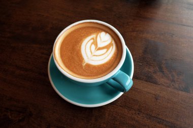 Ahşap bir masa üzerinde sıcak latte