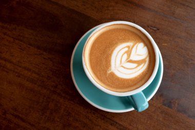 Ahşap bir masa üzerinde sıcak latte