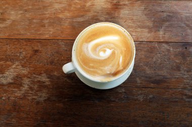 Ahşap bir masa üzerinde sıcak latte