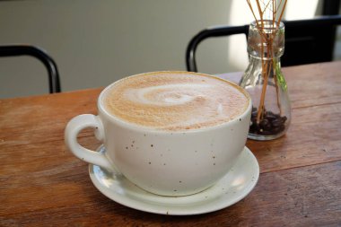 Ahşap bir masa üzerinde sıcak latte