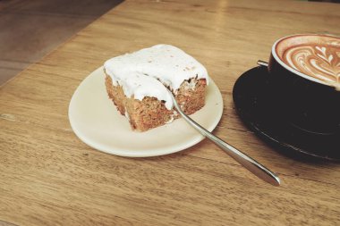 Sıcak latte kahve ile havuç Cheesecake ahşap tablo