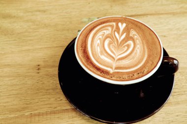 Ahşap bir masa üzerinde sıcak kahve Latte.