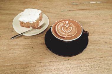 Sıcak latte kahve ile havuç Cheesecake ahşap tablo