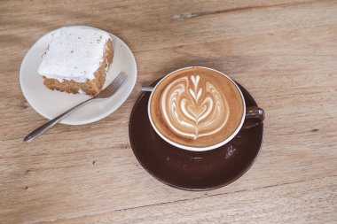 Sıcak latte kahve ile havuç Cheesecake ahşap tablo