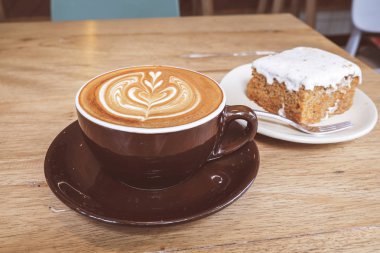 Sıcak latte kahve ile havuç Cheesecake ahşap tablo