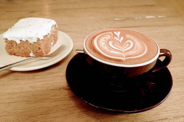 Sıcak latte kahve ile havuç Cheesecake ahşap tablo