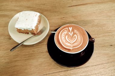 Sıcak latte kahve ile havuç Cheesecake ahşap tablo