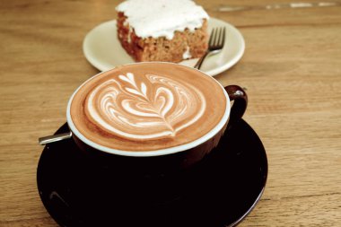 Sıcak latte kahve ile havuç Cheesecake ahşap tablo