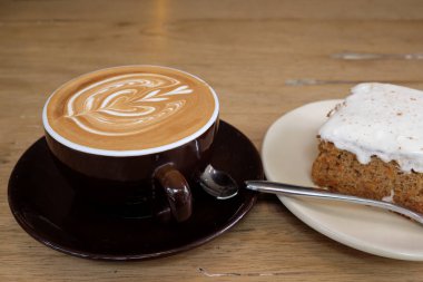 Sıcak latte kahve ile havuç Cheesecake ahşap tablo