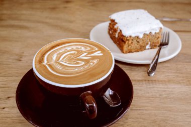 Sıcak latte kahve ile havuç Cheesecake ahşap tablo