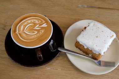 Sıcak latte kahve ile havuç Cheesecake ahşap tablo