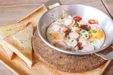 Soslu kızarmış yumurta kahvaltı ve küçük bir tavada tost.