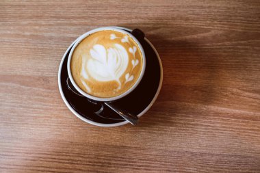 Ahşap zemin üzerinde sıcak Latte Kahve