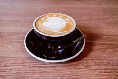 Ahşap zemin üzerinde sıcak Latte Kahve