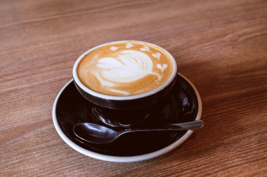 Ahşap zemin üzerinde sıcak Latte Kahve