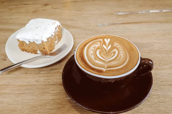 Sıcak latte kahve ile havuç Cheesecake ahşap tablo