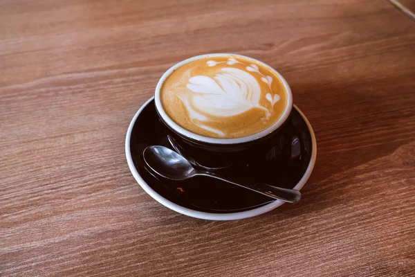 Ahşap zemin üzerinde sıcak Latte Kahve