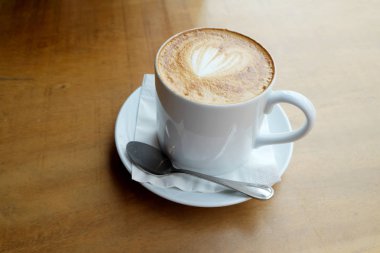 Ahşap bir masa üzerinde sıcak latte