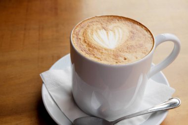 Ahşap bir masa üzerinde sıcak latte