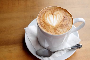 Ahşap bir masa üzerinde sıcak latte