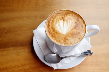 Ahşap bir masa üzerinde sıcak latte