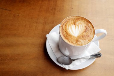 Ahşap bir masa üzerinde sıcak latte