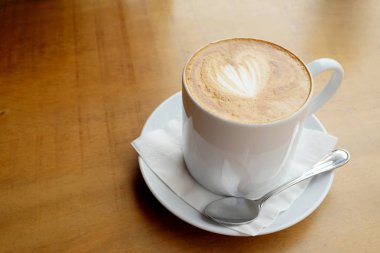 Ahşap bir masa üzerinde sıcak latte