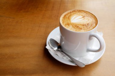 Ahşap bir masa üzerinde sıcak latte