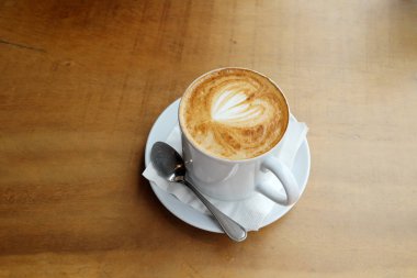 Ahşap bir masa üzerinde sıcak latte