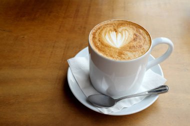 Ahşap bir masa üzerinde sıcak latte