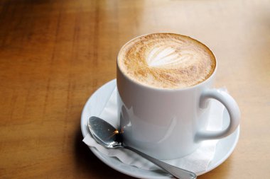 Ahşap bir masa üzerinde sıcak latte