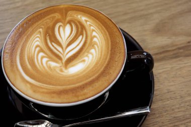 Ahşap bir masa üzerinde sıcak kahve Latte.