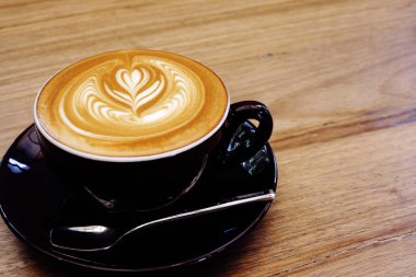 Ahşap bir masa üzerinde sıcak kahve Latte.