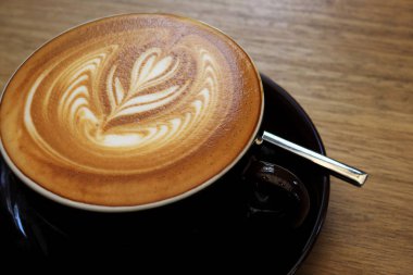Ahşap bir masa üzerinde sıcak kahve Latte.