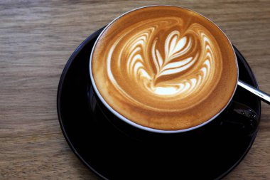 Ahşap bir masa üzerinde sıcak kahve Latte.