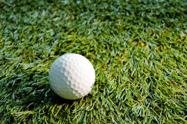 Yeşil çimlerde beyaz golf topu