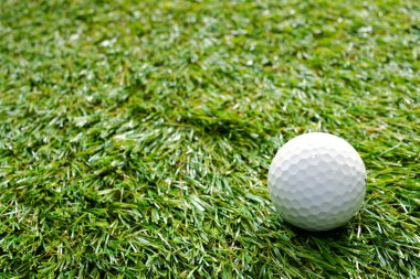 Yeşil çimlerde beyaz golf topu