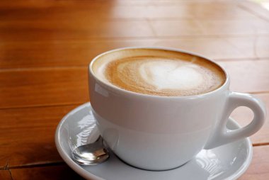 ahşap masa üzerinde beyaz fincan kahve