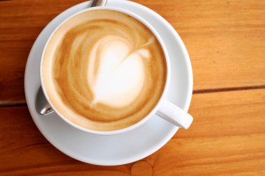 ahşap masa üzerinde beyaz fincan kahve