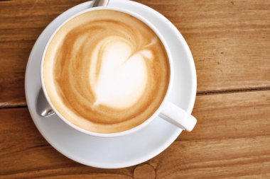 ahşap masa üzerinde beyaz fincan kahve