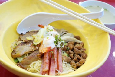 Sarı kabın içinde kızarmış domuz pastırması ile lezzetli erişte