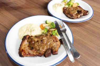 Ahşap arka plan üzerinde sebze ile domuz eti biftek